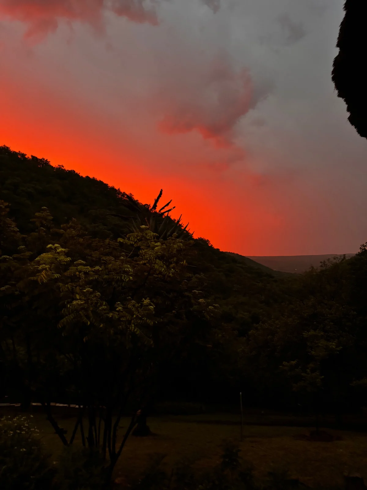 A vivid red and orange evening sky above the valley.