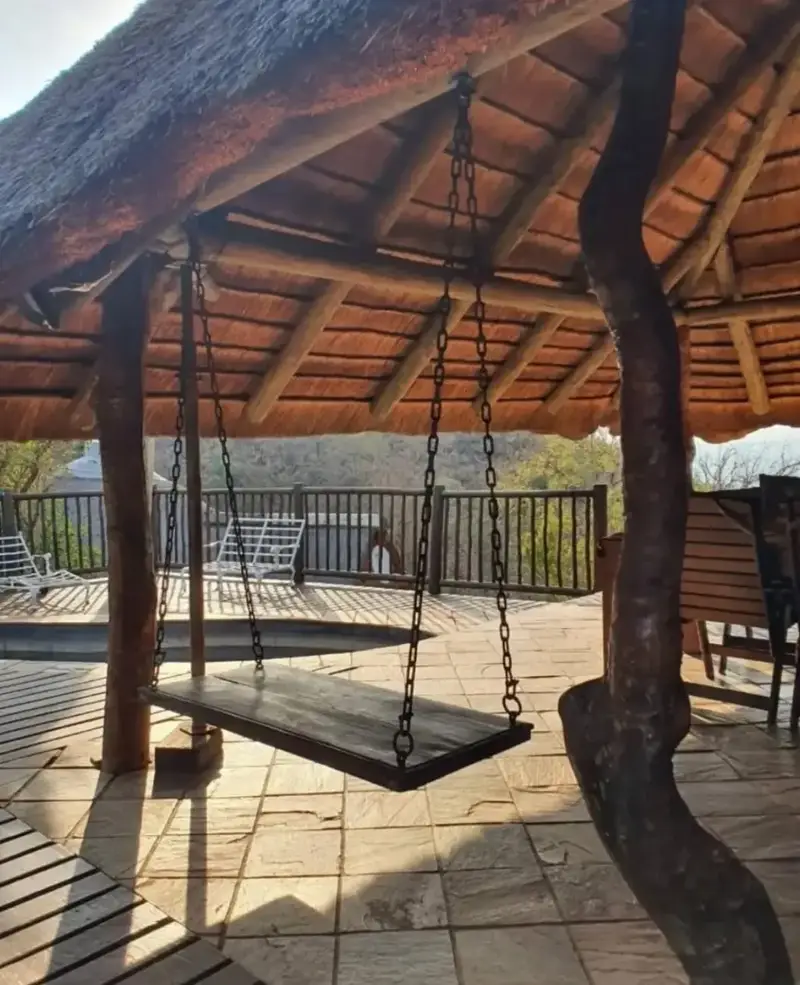 A hanging daybed beneath the thatched roof at Paurosa Game Lodge